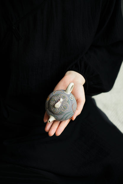Teapot with sculpted pipa lid knob and flowing decorative motifs