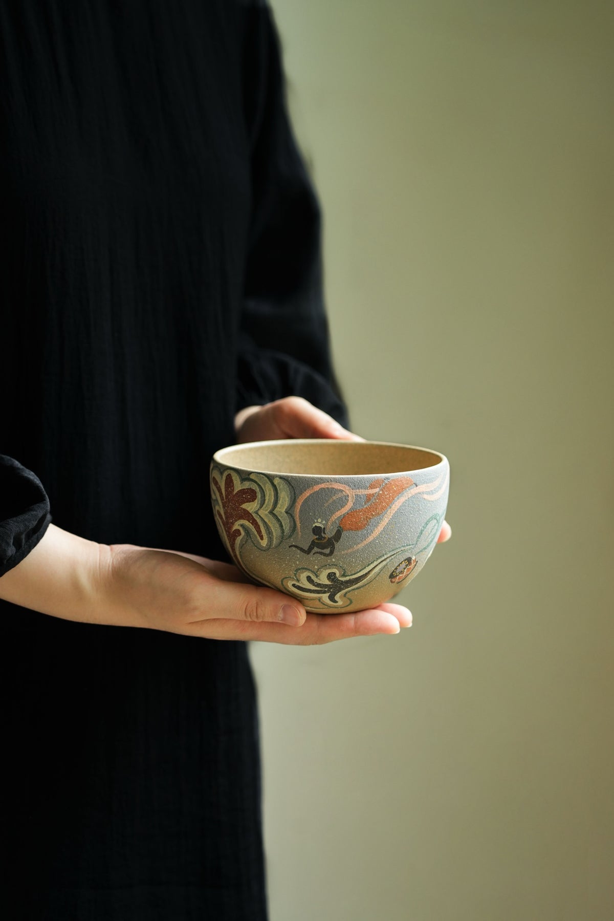 Large decorated tea-rinsing bowl held for scale