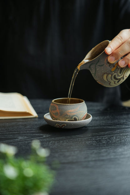 Fairness pitcher pouring tea into the short cup