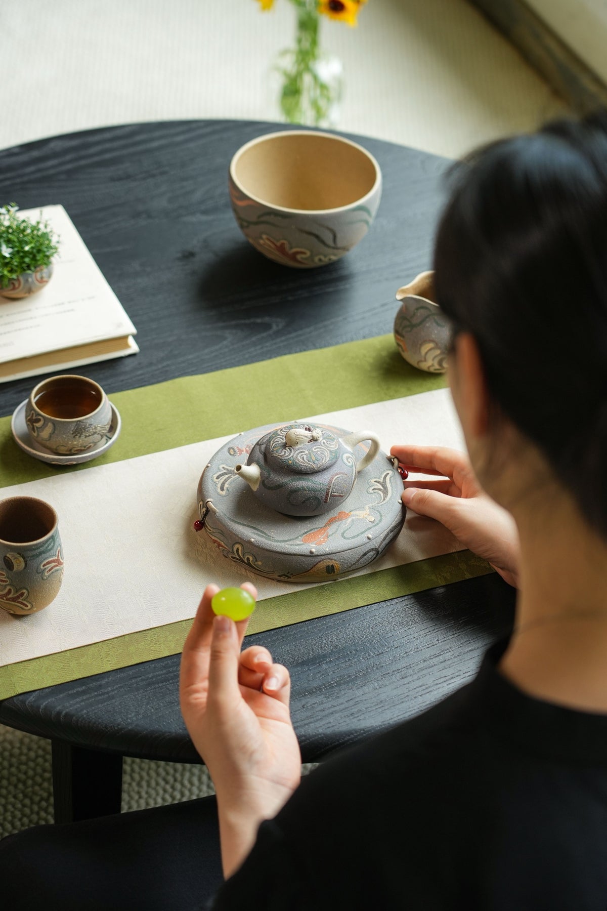 Tea set in use with teapot, reservoir stand, cups and pitcher
