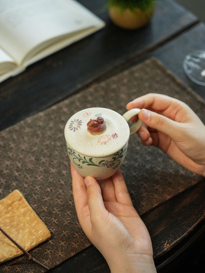 White clay Niu Ma lidded cup with floral clay painting