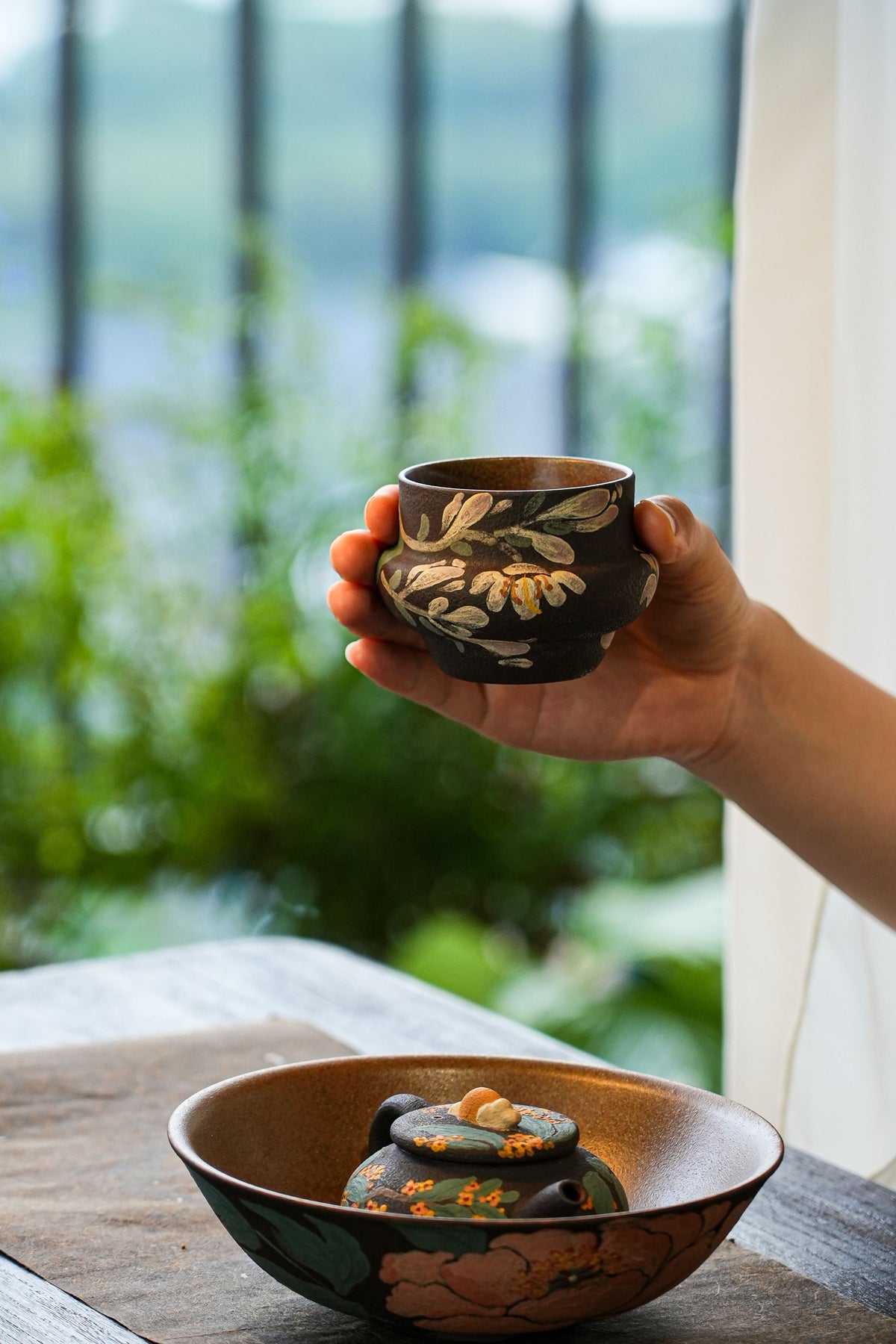Handleless cup above the large bowl and teapot