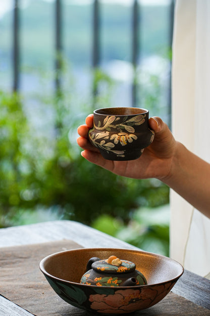 Handleless cup above the large bowl and teapot